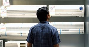 Man looking at air conditioner in supermarket